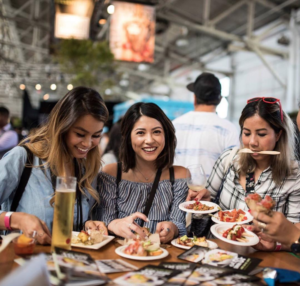 Three women with plates full of food at a table at Eat Drink SF.